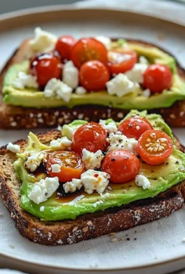 Avocado toast topped with feta cheese and cherry tomatoes on a plate