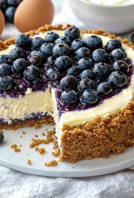 Delicious creamy blueberry cheesecake garnished with fresh blueberries and whipped cream.