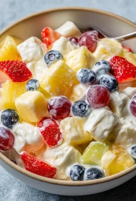 Creamy fruit salad served in a bowl with colorful fruits and a creamy dressing