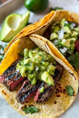 Grilled steak tacos garnished with avocado salsa on a plate