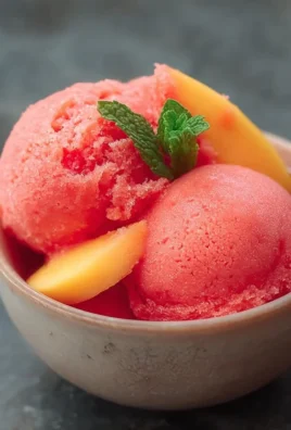Homemade mango strawberry sorbet served in a bowl with fresh fruit on top.