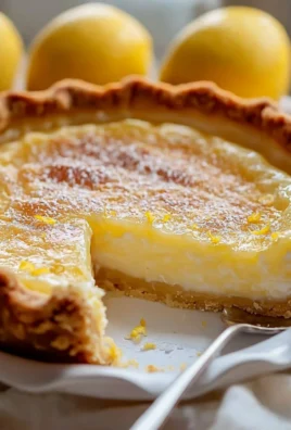 Slice of Impossible Lemon Pie with whipped cream and lemon slices