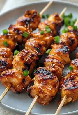 Grilled Korean Chicken Skewers garnished with sesame seeds and green onions