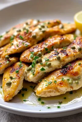Juicy pan fried chicken breast served on a plate with herbs and spices.