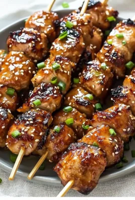 Grilled teriyaki chicken skewers garnished with green onions