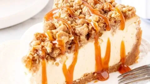 Delicious Apple Crisp Cheesecake topped with crunchy apple crisp.