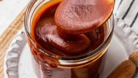 Homemade barbecue sauce in a glass jar with a brush for grilling
