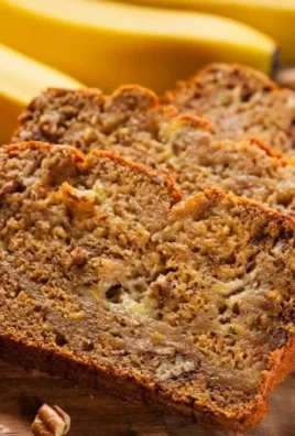 Loaf of freshly baked banana bread topped with walnuts