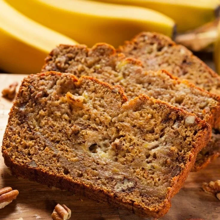 Loaf of freshly baked banana bread topped with walnuts