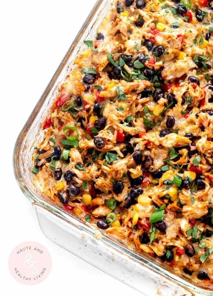 Delicious chicken burrito casserole topped with cheese and fresh vegetables