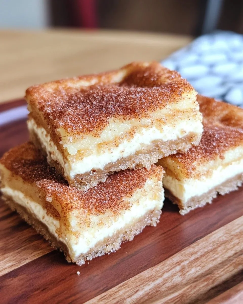 Delicious churro cheesecake bars garnished with cinnamon sugar and drizzled with caramel