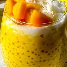 Bowl of easy Mango Sago dessert pudding garnished with fresh mango slices