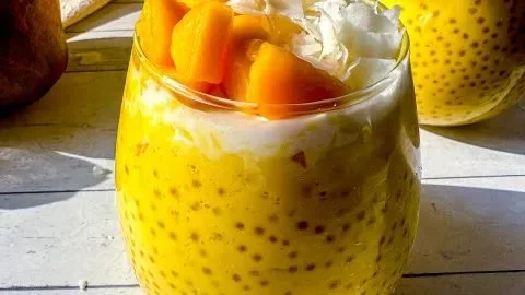Bowl of easy Mango Sago dessert pudding garnished with fresh mango slices