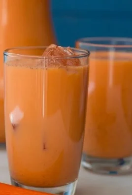 A glass of vibrant Jamaican Carrot Juice, showcasing its bright orange color.