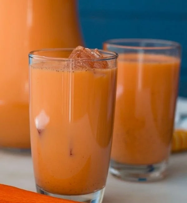 A glass of vibrant Jamaican Carrot Juice, showcasing its bright orange color.