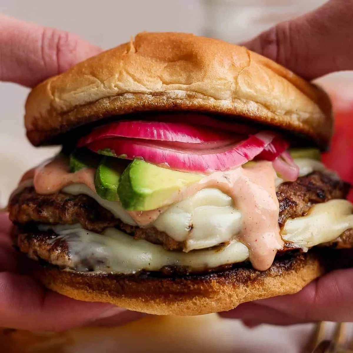 Juicy turkey smash burger with burger sauce and pickled onions on a plate.