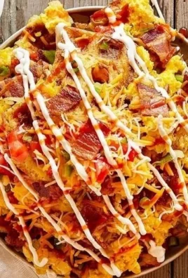 Loaded hash brown nachos topped with cheese and toppings for a tasty breakfast dish.
