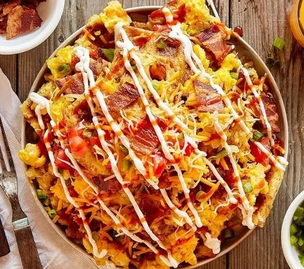 Loaded hash brown nachos topped with cheese and toppings for a tasty breakfast dish.