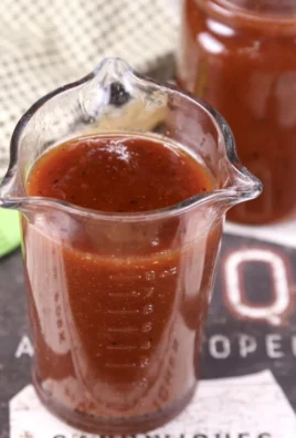 Homemade Maple BBQ Sauce in a glass jar with fresh ingredients