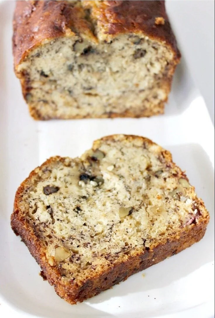 Freshly baked moist banana bread sliced on a wooden board