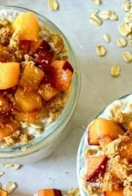 Bowl of Peach Cobbler Overnight Oats topped with fresh peaches and cinnamon