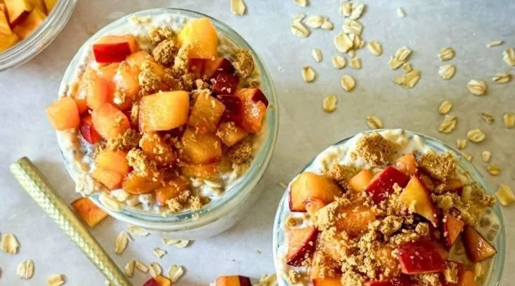 Bowl of Peach Cobbler Overnight Oats topped with fresh peaches and cinnamon
