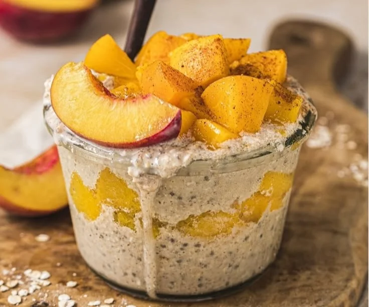 Bowl of peach cobbler overnight oats with fresh peaches and granola