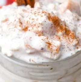 Peaches and cream overnight oats in a jar with fresh peach slices on top