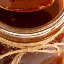 Bottle of Root Beer BBQ Sauce with BBQ grill in the background