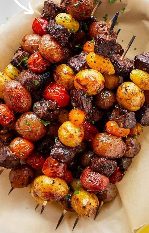 Rosemary garlic steak kebabs ready for grilling, showcasing tender beef chunks and herbs.