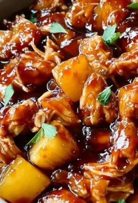 Delicious Sweet Hawaiian Crockpot Chicken garnished with pineapple and herbs.