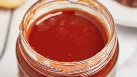 Bottle of homemade Texas BBQ sauce with spices and ingredients displayed