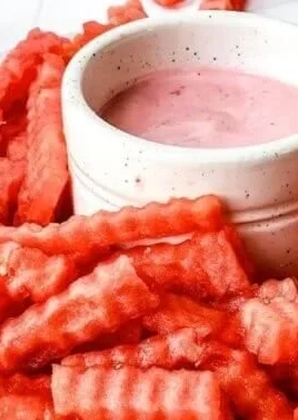 TikTok watermelon fries served with strawberry yogurt dip in a vibrant bowl.