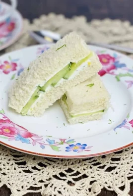 Plate of traditional cucumber sandwiches ready for serving at a tea party.
