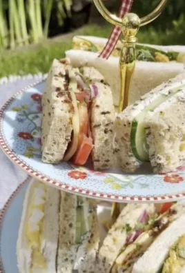A platter of delicious vegetarian afternoon tea sandwiches with fresh vegetables and spreads.