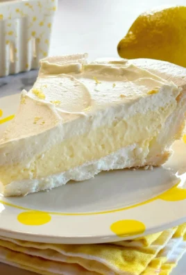 Slice of Vintage Lemon Angel Pie on a plate, showcasing its fluffy texture and lemon filling.