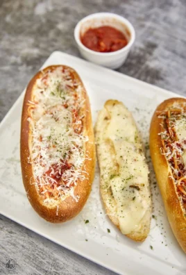 Cheesy garlic bread spaghetti bread boats served on a plate