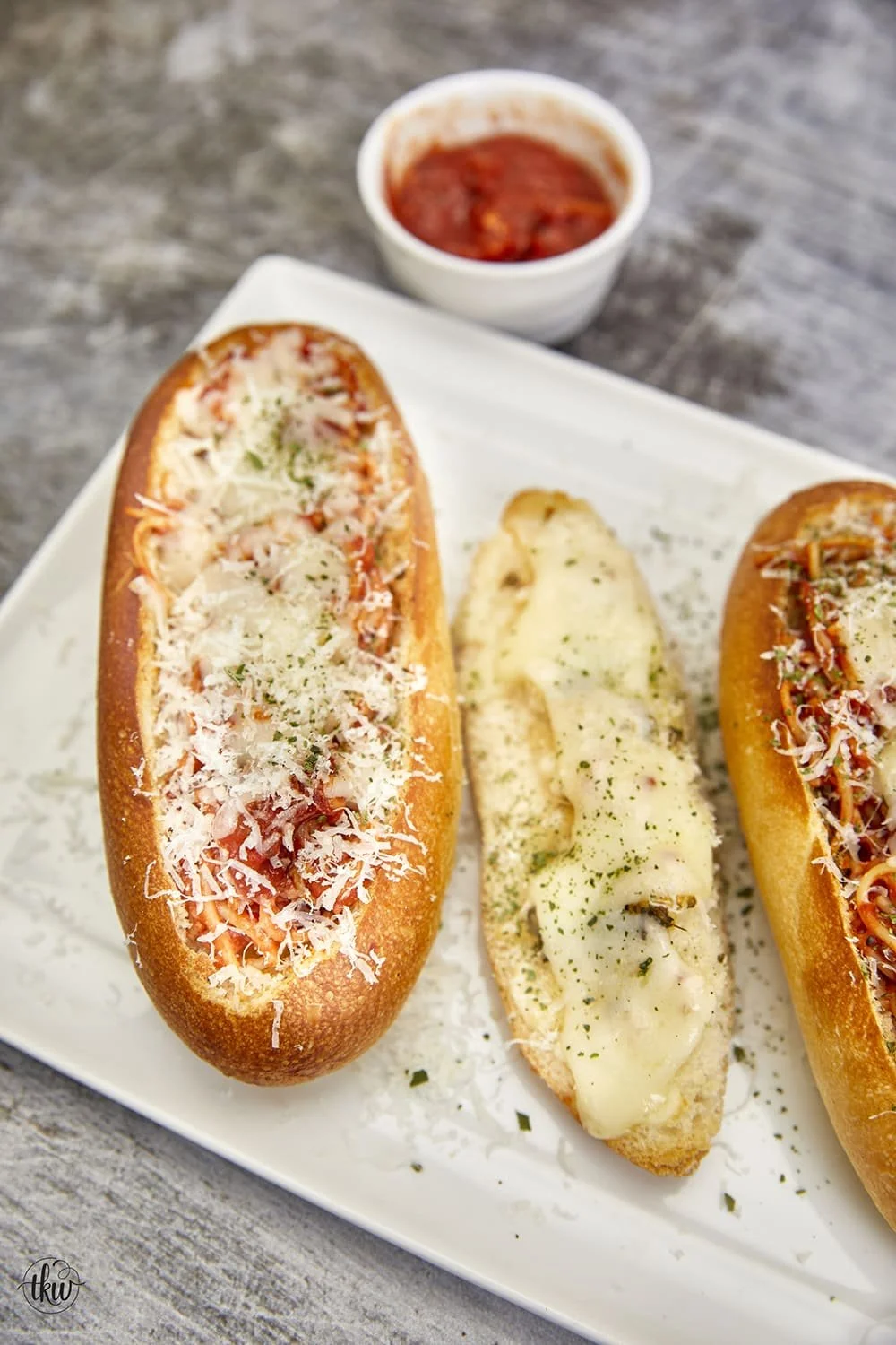 Cheesy garlic bread spaghetti bread boats served on a plate