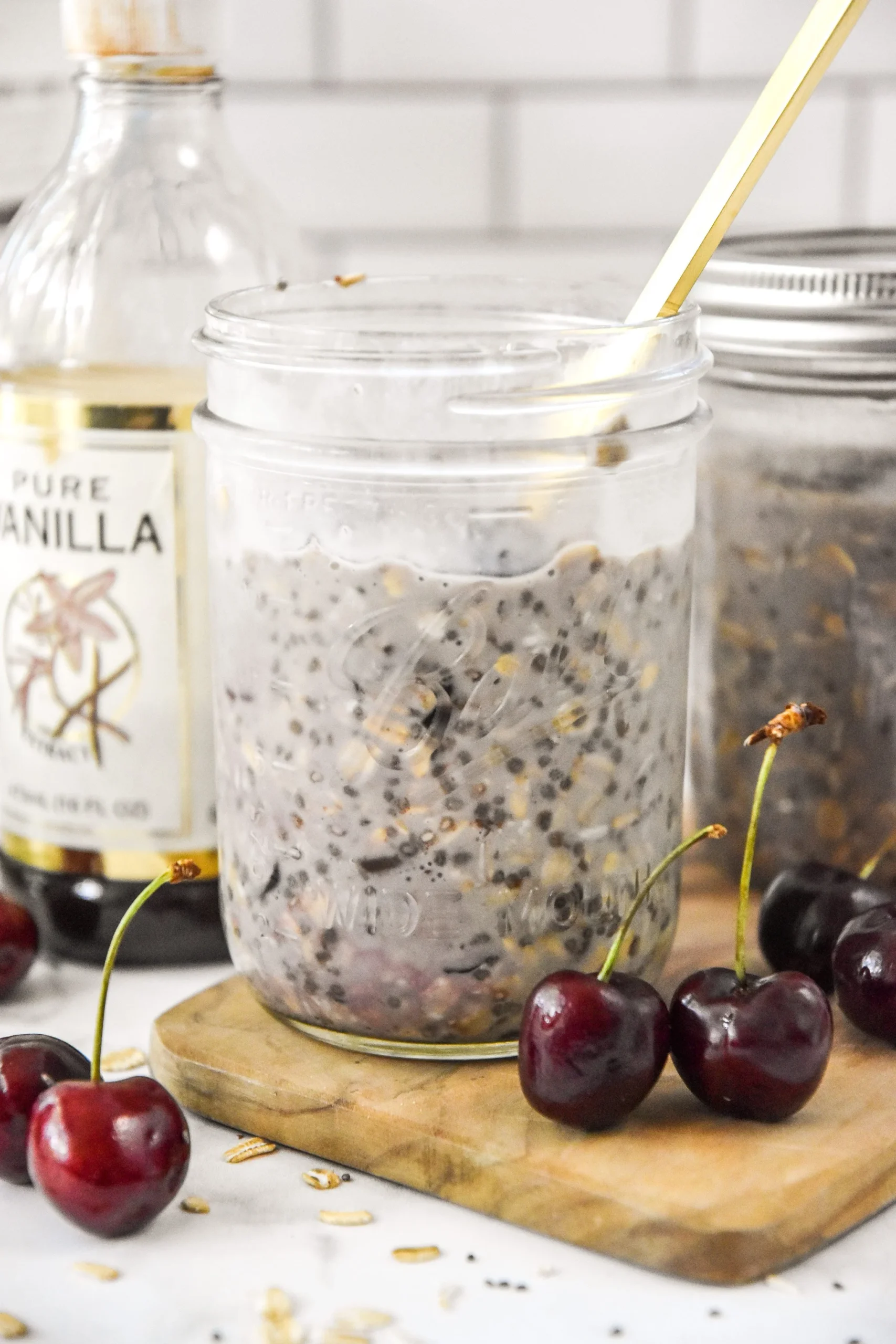 Delicious cherry vanilla overnight oats in a glass bowl topped with fresh cherries.