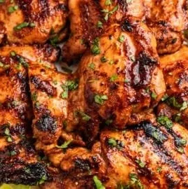 Chili Lime Grilled Chicken served on a plate with fresh herbs and lime wedges
