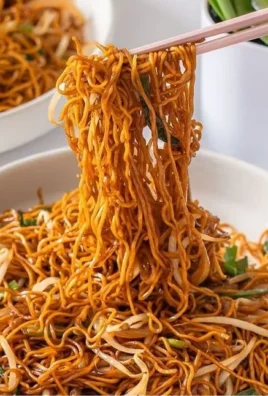 Plate of classic Chinese fried noodles with vegetables and seasoning
