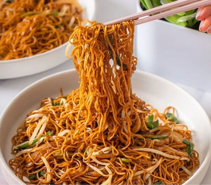 Plate of classic Chinese fried noodles with vegetables and seasoning