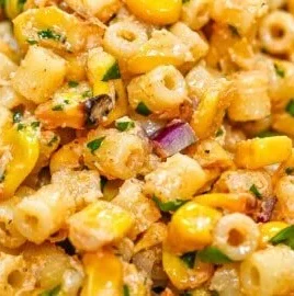 Colorful bowl of corn pasta salad with vegetables and dressing