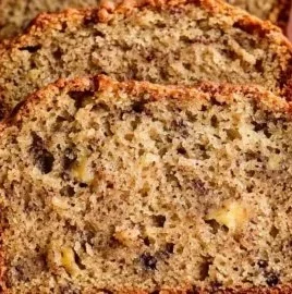 A loaf of easy moist banana bread on a cutting board with sliced pieces.