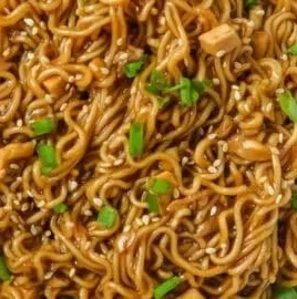 Bowl of easy saucy ramen noodles garnished with green onions and sesame seeds