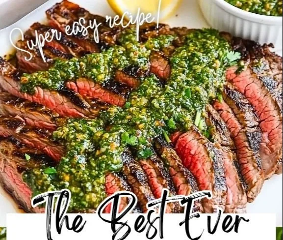 Grilled flank steak topped with vibrant chimichurri sauce on a wooden cutting board.