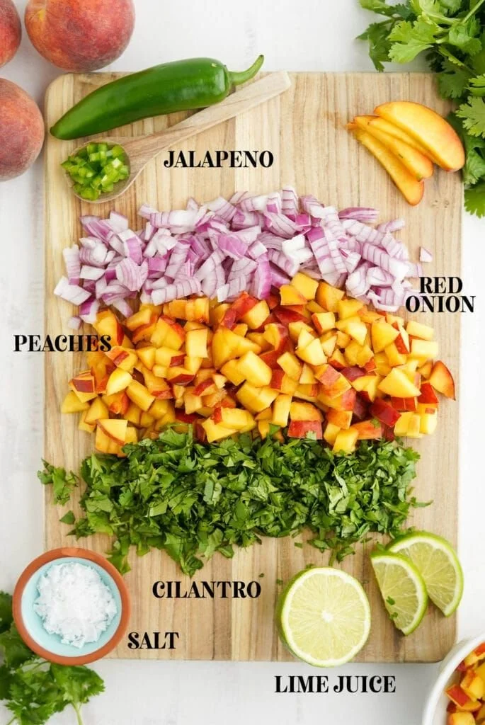 Bowl of fresh peach salsa with colorful ingredients including peaches, onions, and cilantro.