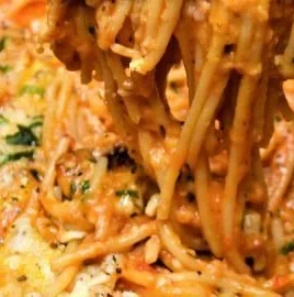 Plate of delicious fried leftover spaghetti garnished with herbs