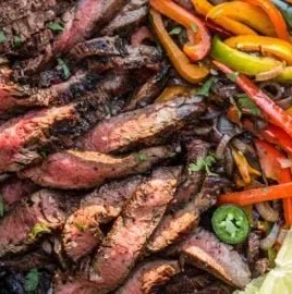 Delicious grilled flank steak fajitas served with vegetables and tortillas