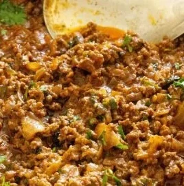 Delicious ground beef curry served in a bowl with spices and herbs.